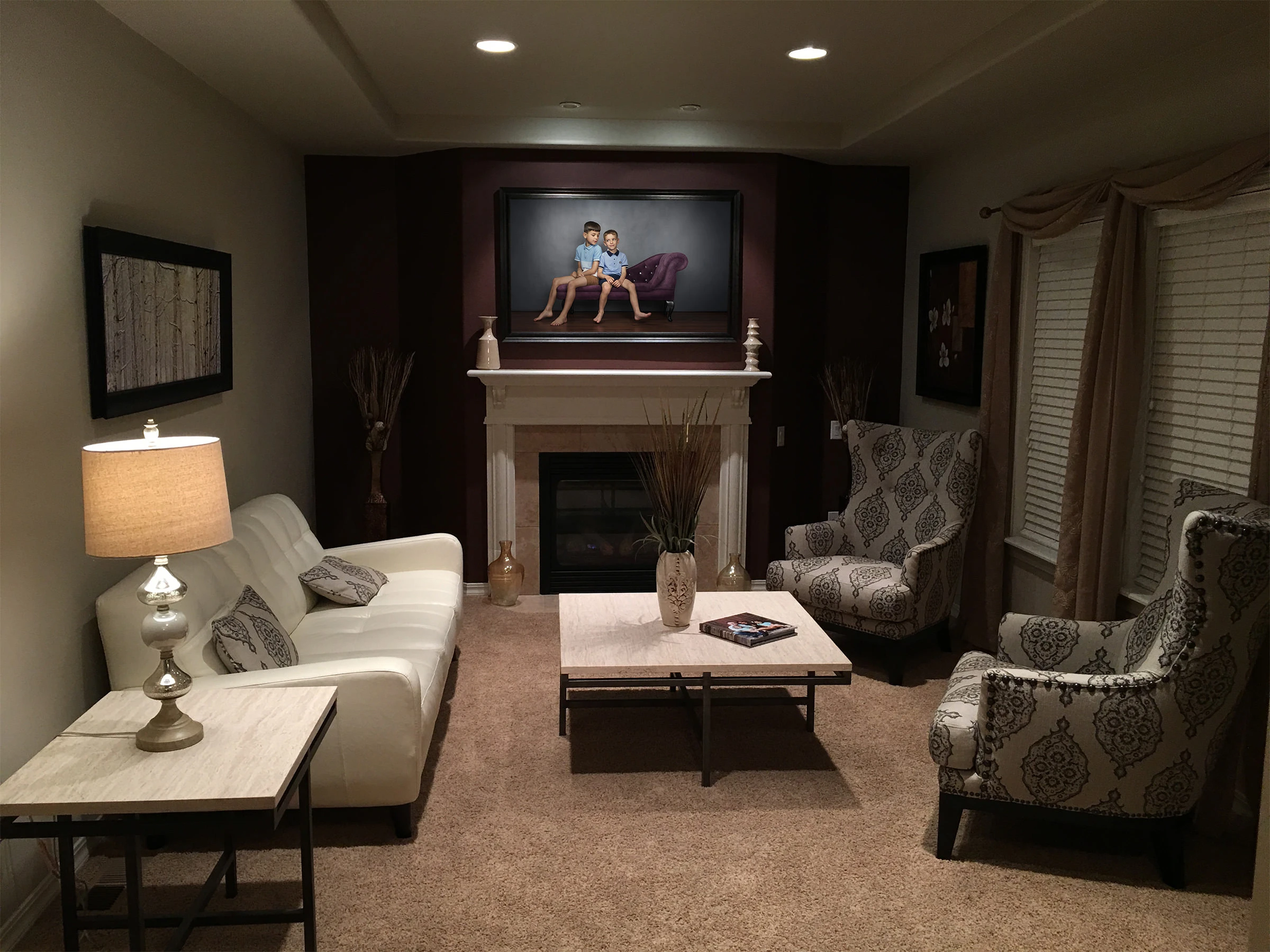 Fine art portrait of children displayed above a fireplace in an elegant living room, showing wall art installation