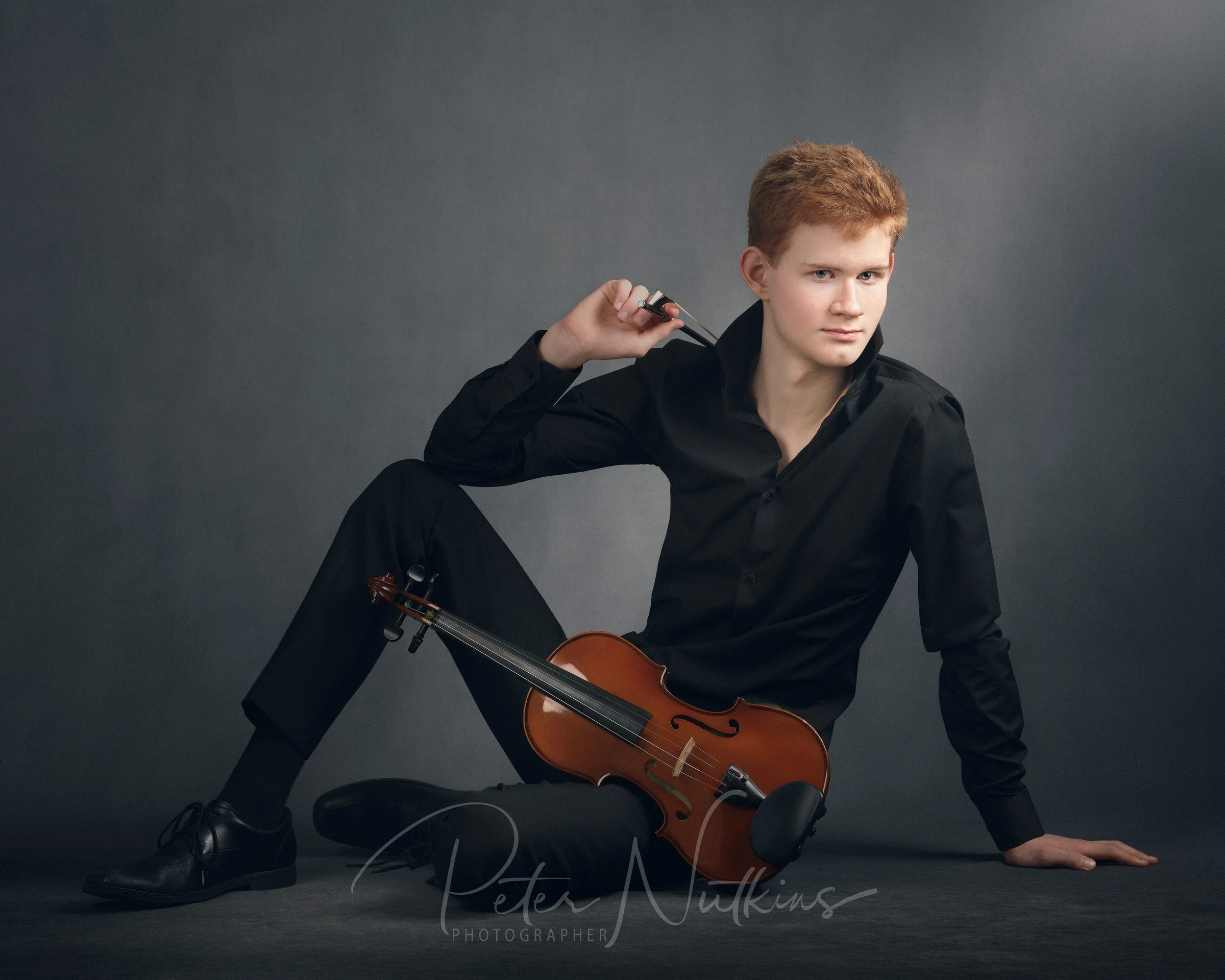 Young violinist in black shirt holding violin and bow, captured in painterly style
